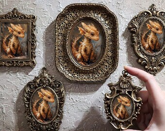 May include: Five ornate gold frames with intricate details, each containing a painting of a small, orange dragon with a light blue background.