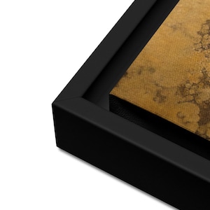 May include: Close-up of a black wood frame surrounding a canvas print with a textured, gold background.