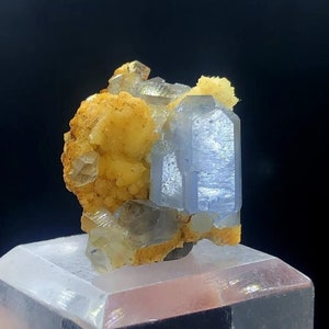 May include: A cluster of light blue, translucent crystals with a yellow, crystalline matrix. The crystals are sharp and well-defined, with a glassy luster.