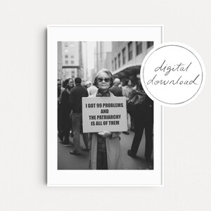 Puede incluir: Fotografía en blanco y negro de una mujer sosteniendo un cartel que dice "I got 99 problems and the patriarchy is all of them".