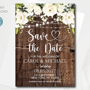 May include: Rustic save the date card with a woodgrain background and white flowers. The text reads "Save the Date" with a heart symbol and "For the wedding of Carol & Michael" followed by the date "Saturday 08.05.2027" and the address "321 Lake Street, New York, NY 43434". The text "Invitation and full details to follow" is at the bottom.
