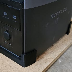 Pu&ograve; includere: Una stazione di alimentazione EcoFlow nera e grigia con pi&ugrave; porte e il logo EcoFlow. La stazione di alimentazione &egrave; su una tavola di legno marrone chiaro. Un trapano giallo e nero &egrave; sullo sfondo.