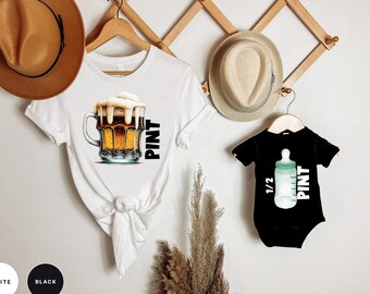May include: White and black t-shirts with a beer mug and a baby bottle graphic. The white t-shirt has the text "PINT" and the black t-shirt has the text "1/2 PINT".