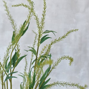 Könnte beinhalten: Ein Bund grüner künstlicher Pflanzenstängel mit langen, dünnen Blättern und kleinen grünen Blüten.