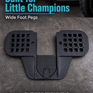 Può includere: Un accessorio poggiapiedi largo di colore nero per bici senza pedali, caratterizzato da una superficie con motivo a griglia per la trazione. Il testo "Built for Little Champions", "Wide Foot Pegs" e "Fits STACYC 12eDRIVE & 16eDRIVE. Not compatible with Elite models" è visibile.