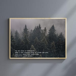 May include: A framed print of a misty forest with a quote about the town of Forks, Washington. The quote reads: "In the state of Washington, under a near constant cover of clouds and rain, there is a small town named Forks. Population: 3,120 people."
