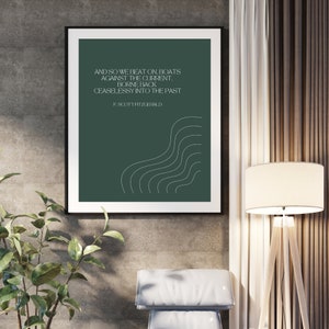 Puede incluir: Un póster verde con una cita blanca de F. Scott Fitzgerald: "Y así seguimos golpeando, barcos contra la corriente. Llevados de regreso sin cesar al pasado." La cita está acompañada de un diseño abstracto blanco de líneas onduladas.