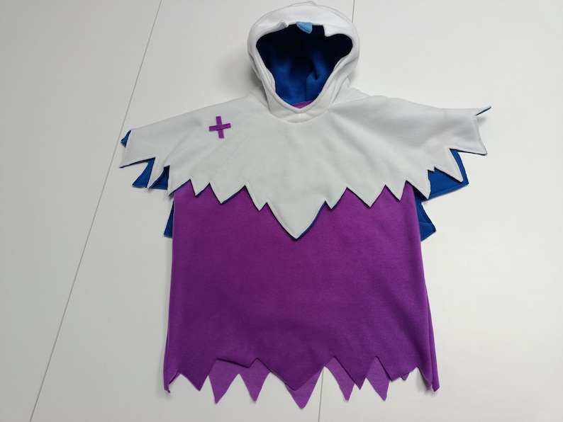 May include: A hooded costume with a white cape and purple body. The cape has a jagged edge and a purple cross on the chest. The hood and cape have blue accents. This costume is suitable for Halloween or cosplay.