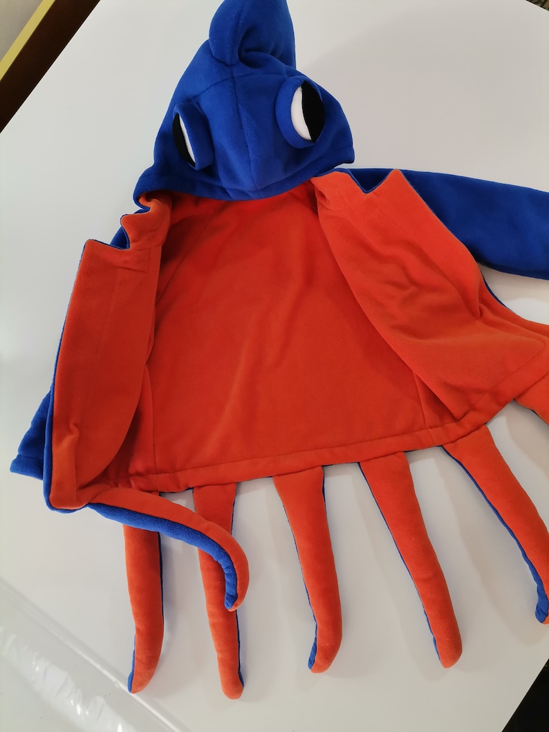 May include: Blue and orange octopus costume with a hood and large eyes. The costume is open to show the orange fleece lining.