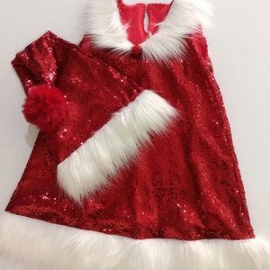 May include: Red sequined dress with white faux fur trim and a matching red sequined Santa hat with a white pom-pom.