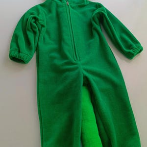 May include: Green fleece chameleon costume for kids with a long tail and large eyes.