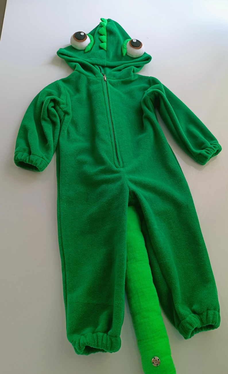 May include: Green fleece chameleon costume for kids with a long tail and large eyes.