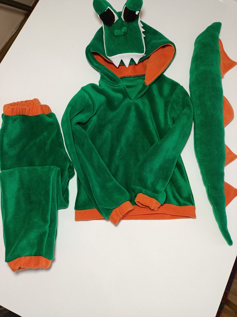 Peut inclure: Costume d'alligator vert et orange pour enfants. Le costume comprend un sweat &agrave; capuche, un pantalon et une queue.