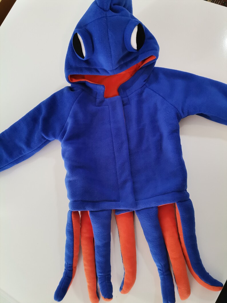 May include: Blue and orange octopus costume for a child. The costume has a hood with large eyes and a zipper closure. The bottom of the costume has eight tentacles.