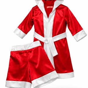 May include: A red satin boxing robe and shorts set with white trim. The robe has a hood, a white lapel, and a matching belt. The shorts also have white trim. This boxing outfit is perfect for costume parties or themed events.