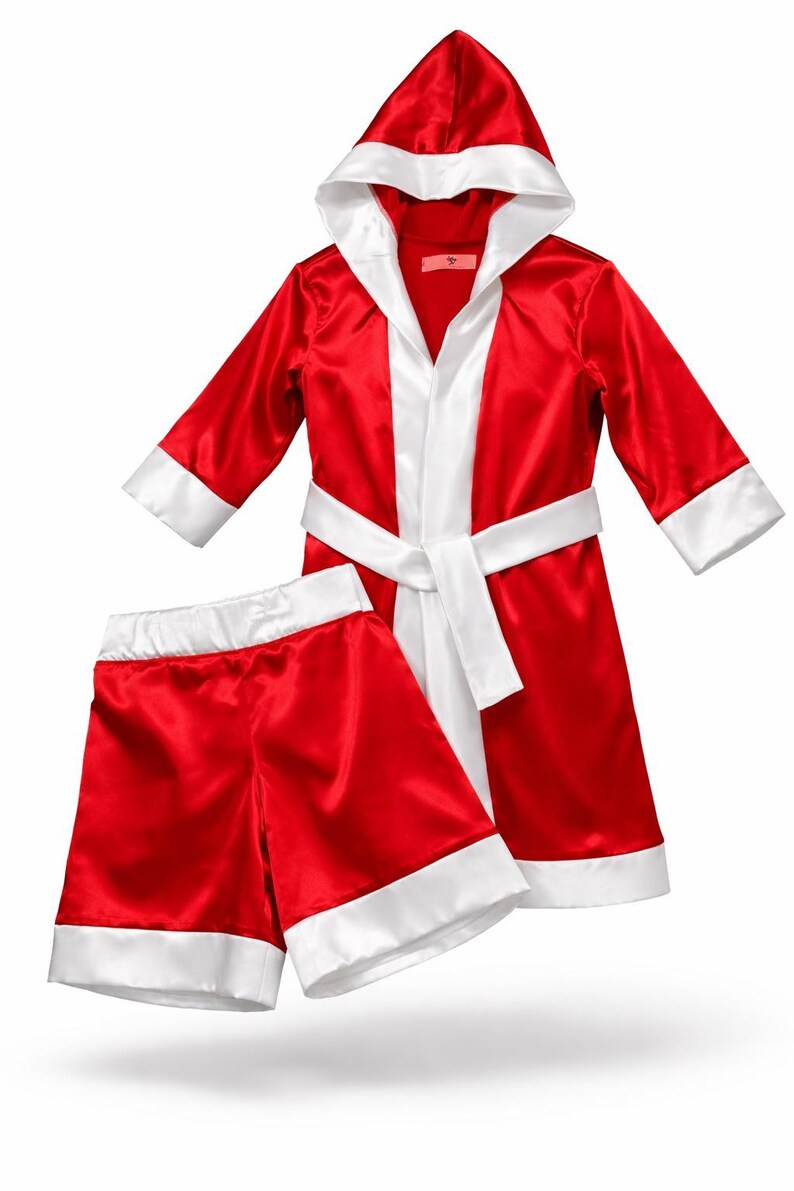 May include: A red satin boxing robe and shorts set with white trim. The robe has a hood, a white lapel, and a matching belt. The shorts also have white trim. This boxing outfit is perfect for costume parties or themed events.
