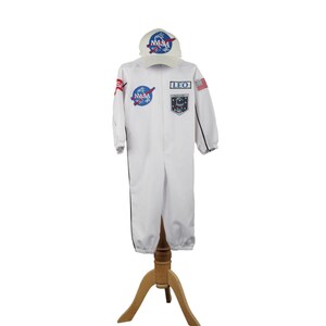 Może przedstawiać: Biały kostium astronauty z naszywkami NASA i pasującą czapką. Kostium ma czarne wykończenia i napis "LEO" na piersi. Czapka ma logo NASA. Kostium jest prezentowany na drewnianym stojaku.