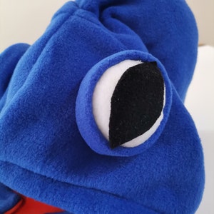 May include: Blue fleece hooded costume with a large white eye with a black pupil.