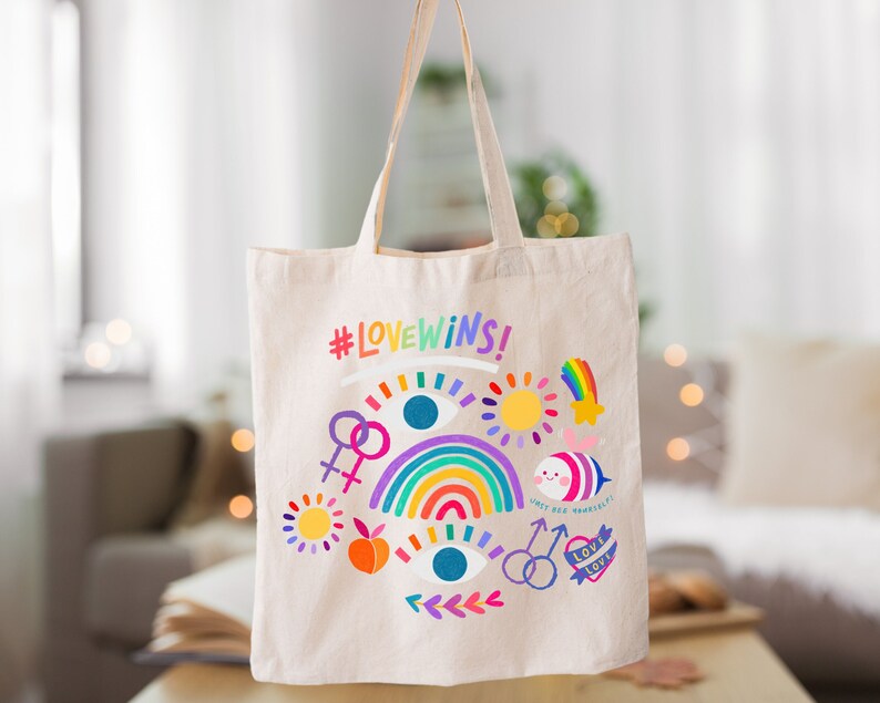 May include: A white canvas tote bag with a rainbow, hearts, and the text "#LOVEWINS!" printed on it. The bag has a colorful design with a rainbow, hearts, and the text "#LOVEWINS!" printed on it.