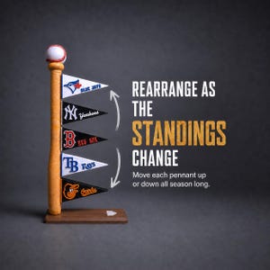 May include: A wooden baseball bat stand topped with a baseball, featuring five triangular team pennants for the Blue Jays, Yankees, Red Sox, Rays, and Orioles. Text reads: REARRANGE AS THE STANDINGS CHANGE. Move each pennant up or down all season long.