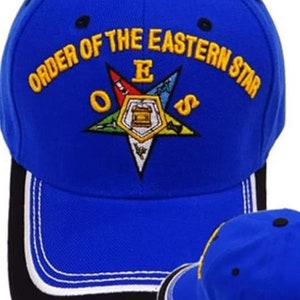 Puede incluir: Una gorra de béisbol azul real con una visera blanca y negra. La parte delantera de la gorra presenta un emblema bordado en amarillo con el texto "Order of the Eastern Star" y una estrella de cinco puntas con una brújula y una escuadra.