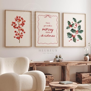May include: Three framed wall art prints featuring Christmas themes. The left print shows red berries on a branch, the centre print displays the red text "have yourself a merry little christmas" in a decorative border, and the right print shows holly.