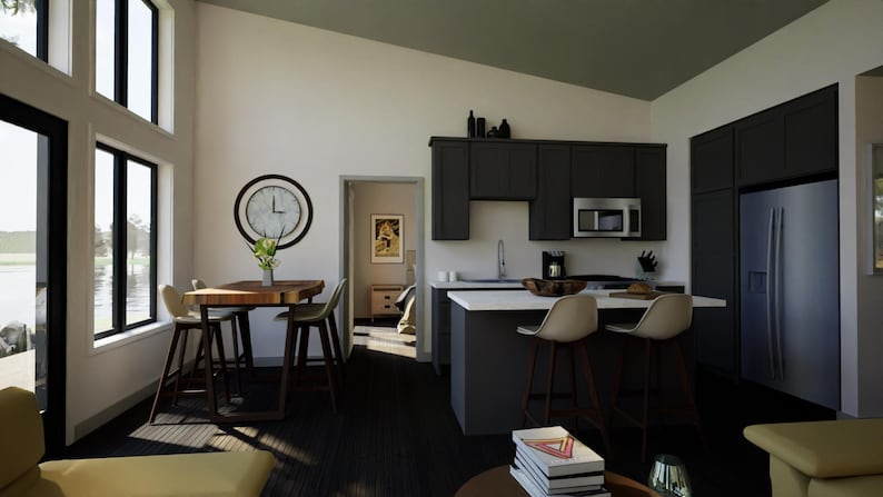 May include: Interior shot of a modern kitchen and dining area. Features include dark gray cabinetry, a stainless steel refrigerator, and a breakfast bar with stools. A wooden dining table with chairs and a large clock are also visible.