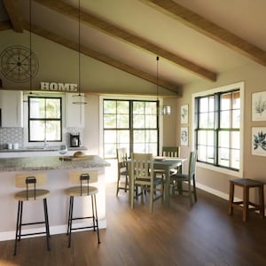 Great room with large windows and fireplace – open to kitchen/dining. Vaulted ceilings for bright, airy interior feel.