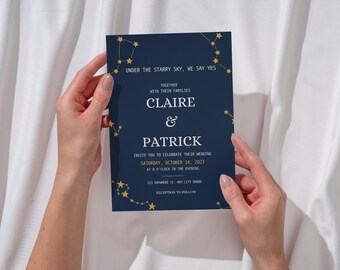May include: A navy blue wedding invitation with gold constellation accents. The invitation includes the text "Under the Starry Sky, We Say Yes" and invites guests to celebrate Claire & Patrick's wedding on October 14, 2023.