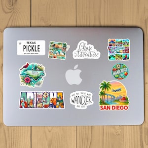 Puede incluir: Una colecci&oacute;n de pegatinas con tem&aacute;tica de viajes en un ordenador port&aacute;til. Las pegatinas incluyen textos como "Texas Pickle", "Chase Adventure", "Arizona" y "San Diego". Las pegatinas presentan varias ilustraciones y dise&ntilde;os.