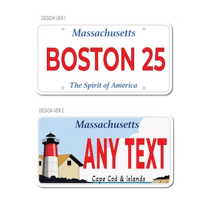 May include: Two designs for a Massachusetts license plate. The first design is white with blue text and red text that says "Massachusetts", "BOSTON 25", and "The Spirit of America". The second design is white with blue text and red text that says "Massachusetts", "ANY TEXT", and "Cape Cod & Islands". The second design also features a red and white lighthouse.