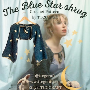 May include: The Blue Star Shrug crochet pattern by TTCG Craft. A blue crochet shrug with gold stars and a crescent moon detail. The shrug is hanging on a wooden hanger. The pattern is available for purchase on Etsy.