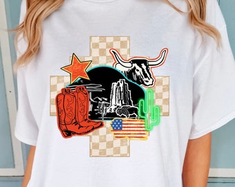 May include: White t-shirt with a graphic design featuring a checkered background, cowboy boots, a bull, a cactus, a star, and an American flag.