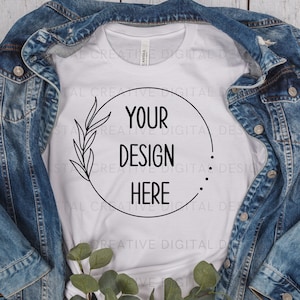 May include: White t-shirt with a black circle design featuring a leafy branch and the text "YOUR DESIGN HERE".