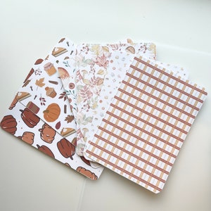May include: Four different patterned cards with fall themes. The cards feature pumpkins, leaves, plaid, and other fall-themed designs.