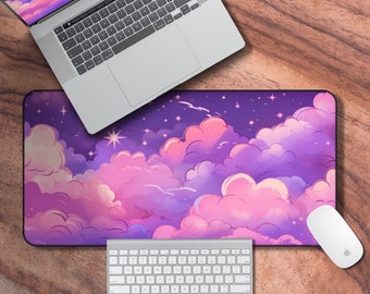 Puede incluir: Un ratón de ordenador con temática de nubes de color morado y rosa con un portátil, un teclado y un ratón encima. El ratón de ordenador tiene un cielo nocturno estrellado con nubes esponjosas.