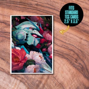 K&ouml;nnte beinhalten: Eine Sammelkarte mit einem t&uuml;rkis-roten Roboterdesign, umgeben von rosa und wei&szlig;en Blumen. Die Karte ist mit "FITS STANDARD TCG CARDS 2.5" X 3.5"" in einem schwarzen Kreis mit gelbem Pfeil beschriftet. Misst 6,35 cm x 8,89 cm.