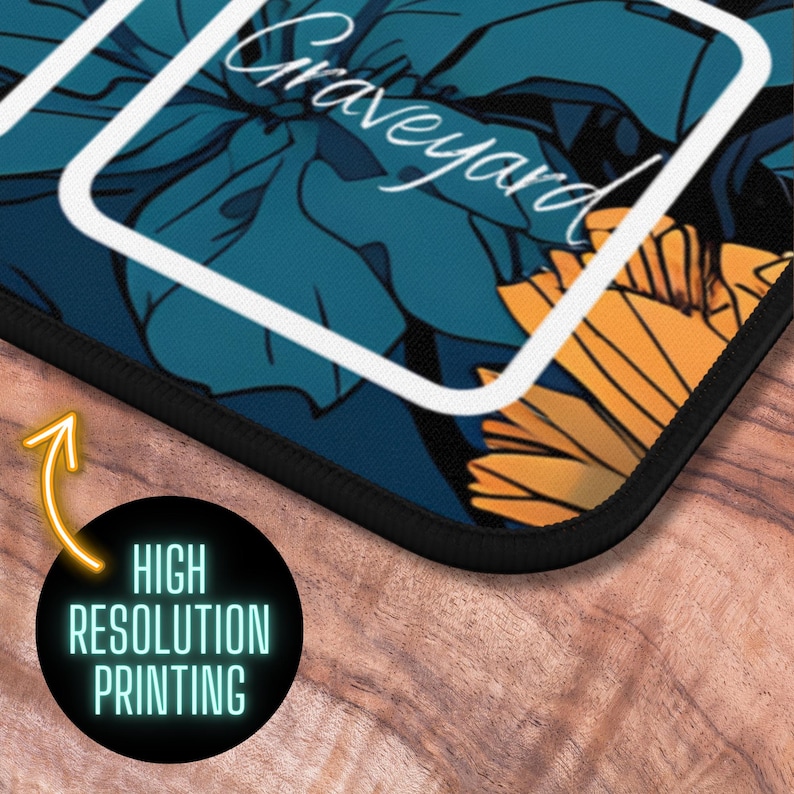 May include: A teal blue and yellow floral mousepad with a white border and the word "Graveyard" written in white cursive.