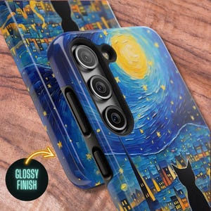 May include: A phone case with a glossy finish featuring a starry night sky with a yellow moon and a black silhouette of a cat in the foreground. The case has a cutout for the camera lens.