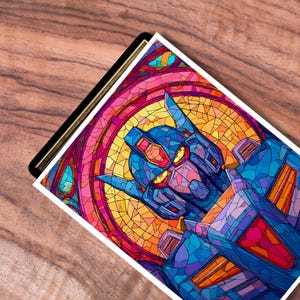 May include: A colorful art print featuring a robot design in a stained-glass style. The robot is primarily blue with red and yellow accents, set against a backdrop of vibrant pink, orange, and yellow hues. The artwork is on a white background.