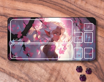 May include: A black and white playmat with a fantasy illustration of a female elf with white hair and pink flowers. The playmat has labeled sections for life, command zone, exile, library, graveyard, battlefield, and lands.