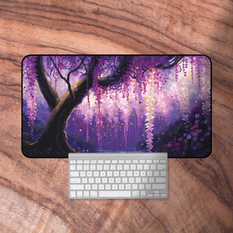 May include: A purple and pink floral mousepad with a large tree with cascading flowers. The mousepad is on a wooden surface.
