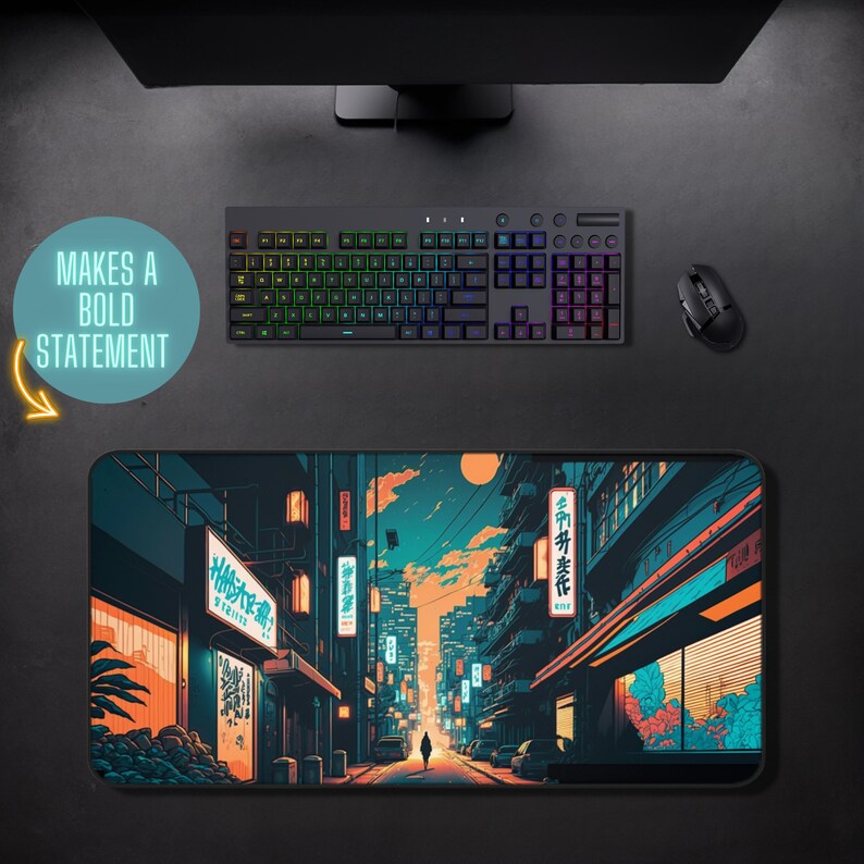 May include: A black and blue mousepad with a colorful illustration of a Japanese city street at night. The street is lined with buildings and shops with glowing neon signs. The text on the signs reads "待ち合わせ" and "博多ラーメン".