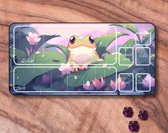 Puede incluir: Una rana de árbol verde se sienta en una hoja verde con flores rosas. La rana está rodeada de hojas verdes y flores rosas. La imagen es una estera de juego para un juego de mesa con etiquetas para diferentes zonas de juego, incluyendo "Campo de batalla", "Tierras", "Exilio", "Cementerio", "Biblioteca" y "Zona de mando".