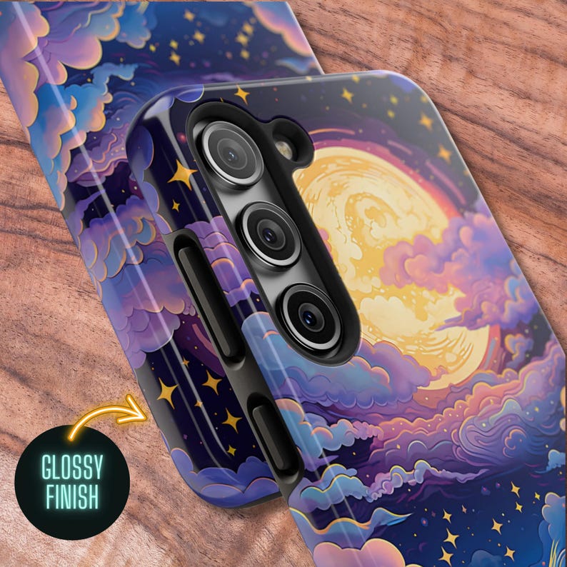 May include: A phone case with a glossy finish featuring a full moon and clouds in shades of purple, blue, and yellow against a dark blue background with gold stars.