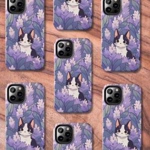 May include: A set of ten phone cases featuring a black and white cat with purple flowers. The cases are designed for a variety of phone models.