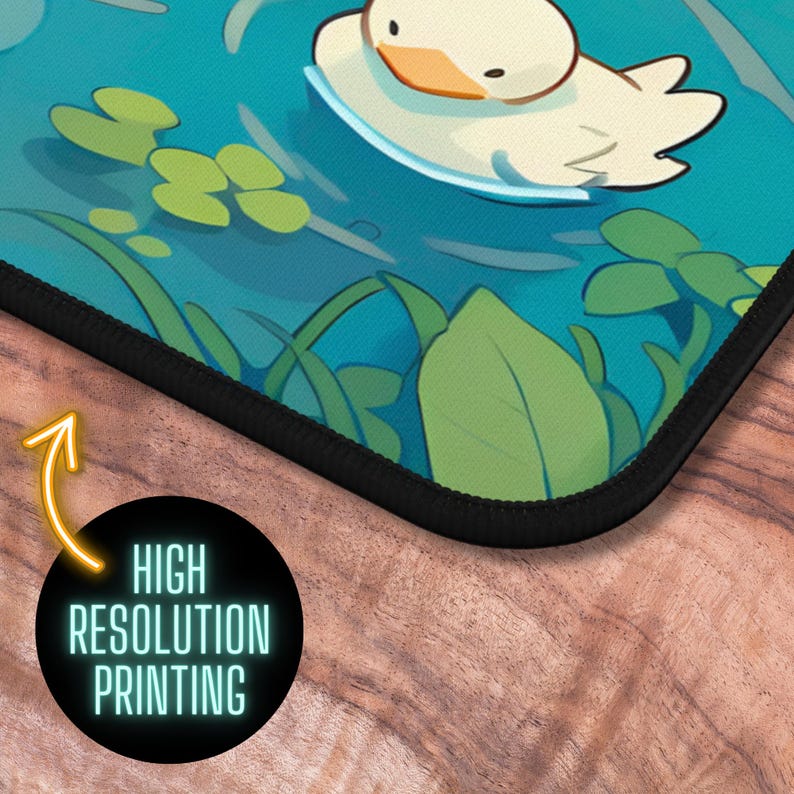 May include: A mousepad featuring a cartoon duck swimming in a blue pond with green lily pads. The mousepad has a black stitched edge.