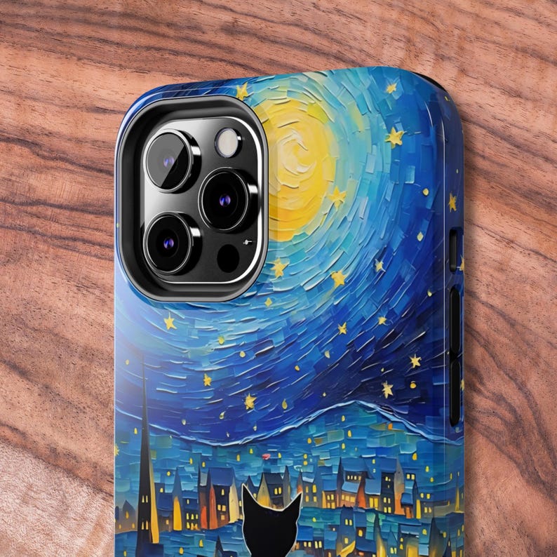 May include: A phone case with a starry night painting design. The painting features a yellow moon, blue sky, and a silhouette of a cat in front of a city skyline.
