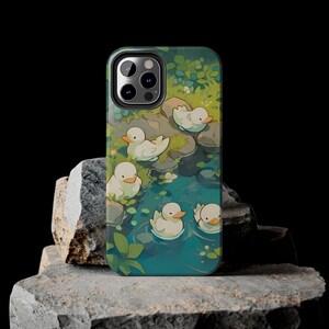 May include: A phone case with a green and blue design featuring white ducks swimming in a pond. The case has a camera lens cutout and a white border.