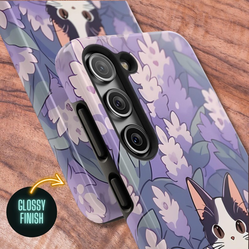 May include: A purple and white floral phone case with a black and white cat illustration. The case has a glossy finish and a camera cutout for a triple lens camera.